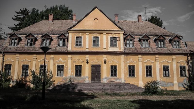 Törpike a kastélyban - így fest a Balaton déli partján álló, pusztulásra ítélt rezidencia. A romos falak között időtlen titkok rejtőznek, és a természet lassan visszaveszi, ami egykor az emberé volt. A kastély impozáns árnyéka még mindig lenyűgöző, de a f